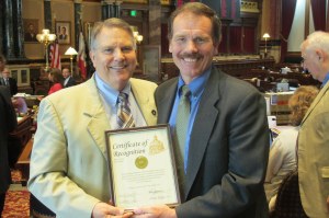 Del Christensen (right), Executive Director for Iowa Resource for International Service (IRIS), accepts the Iowa Senate certificate of recognition, which is presented by Senator Daryl Beall (left). 